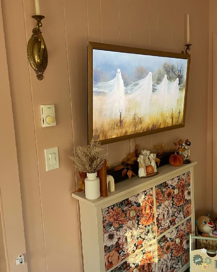 Shoe cabinet with floral wallpaper over top and TV