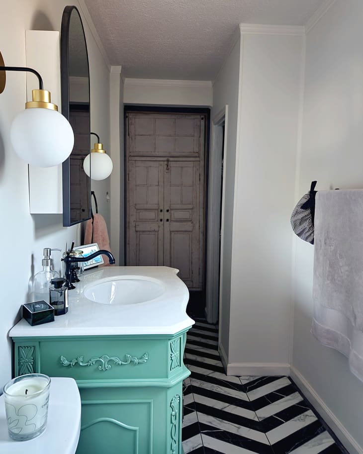 Bathroom with green vanity after renovation.