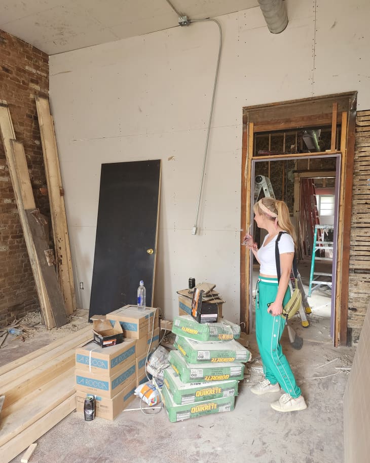 Dweller standing in living room during renovation.
