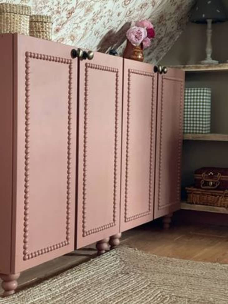 dusty pink banquet cabinet with round border detail and brass knobs