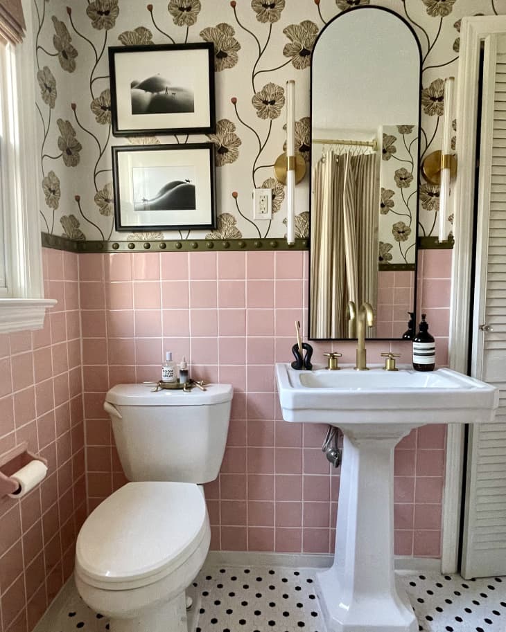 bathroom with pink tile, arched mirror, botanical wallpaper, and gold hardware/accents after remodel