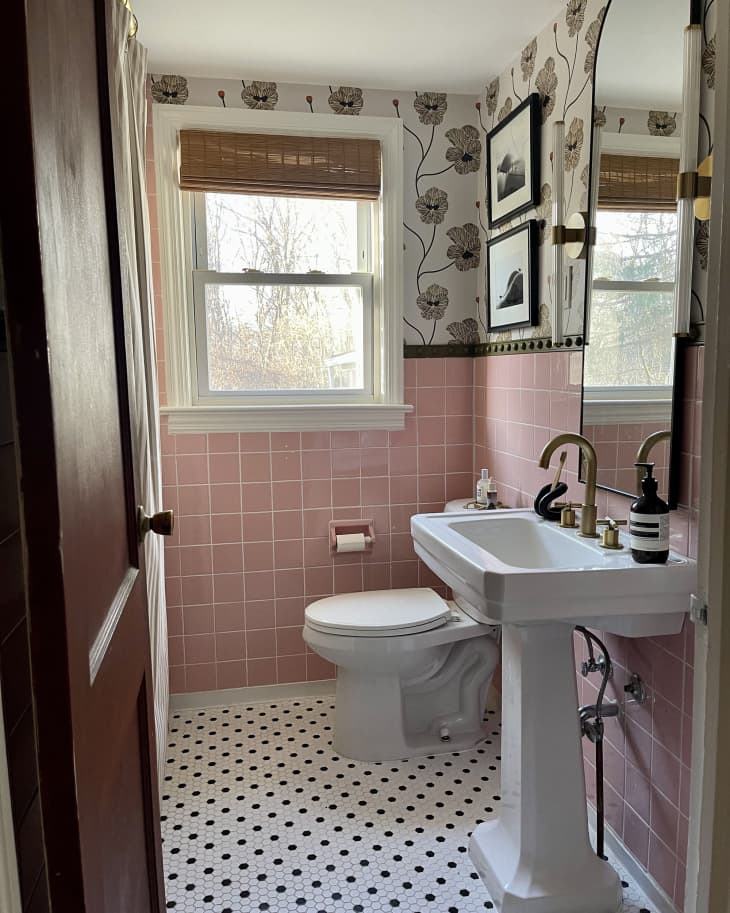 bathroom with pink tile, arched mirror, botanical wallpaper, and gold hardware/accents after remodel