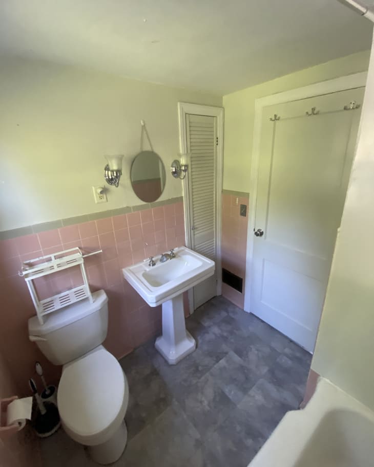 white bathroom with pink tile and gray floor before remodel