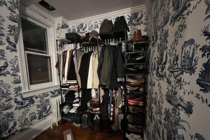 Exposed closet in dark corner of toile wallpaper room