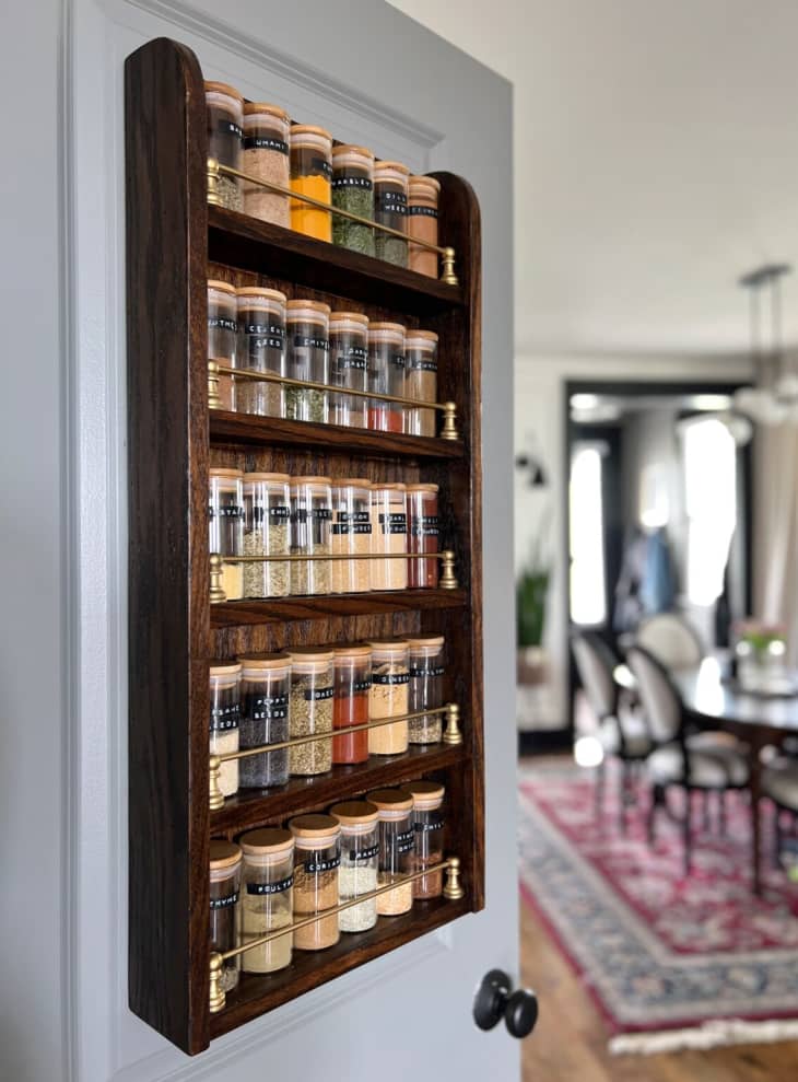 Wood spice rack full of spices mounted on wall