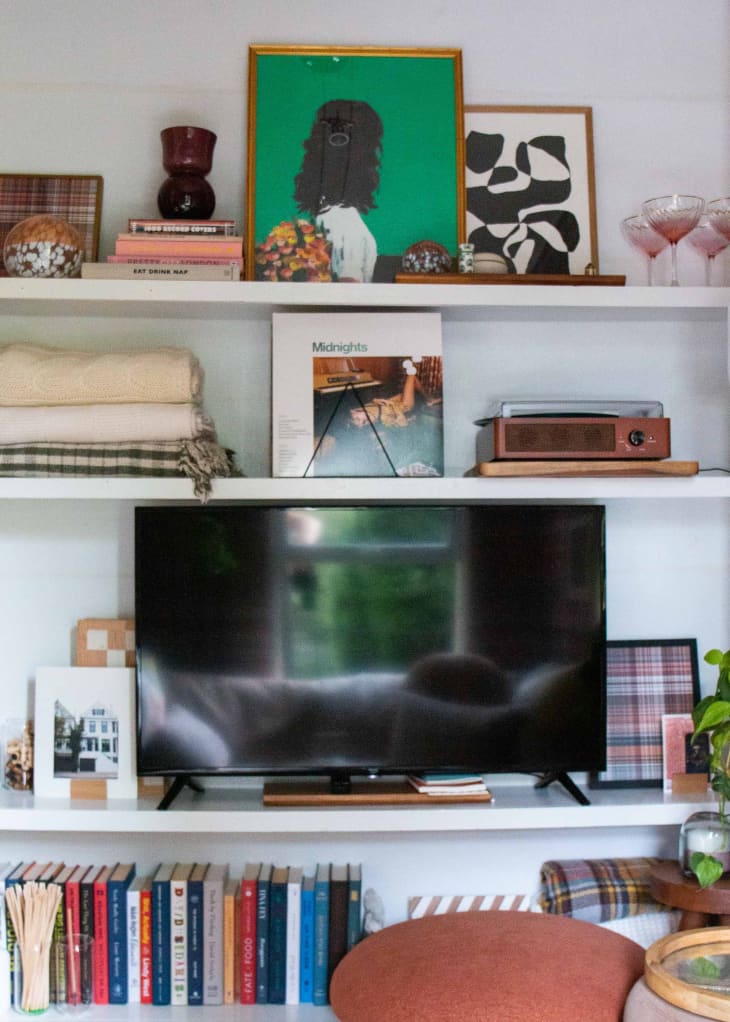 Build in white shelving with a TV, books, and other decorative items.