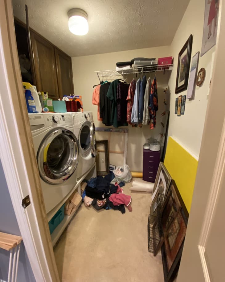 Wooden cabinets with washer and dryer underneath, messy top with detergent and cleaning supplies everywhere, clothes hanging on rack, pile of clothes on floor