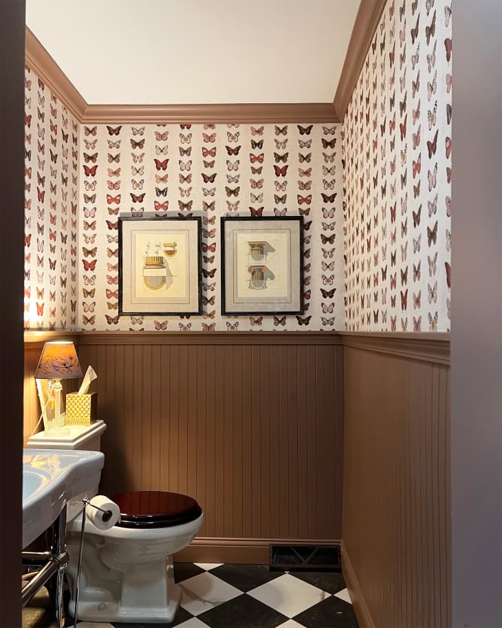 Brown painted wainscoting in bathroom with butterfly wallpaper.