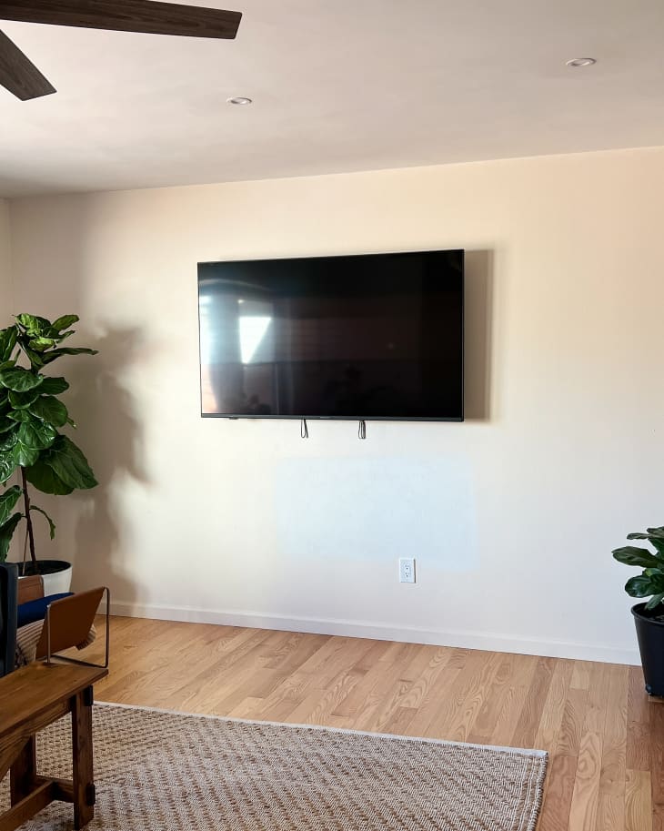 white blank living room wall with mounted TV before remodel