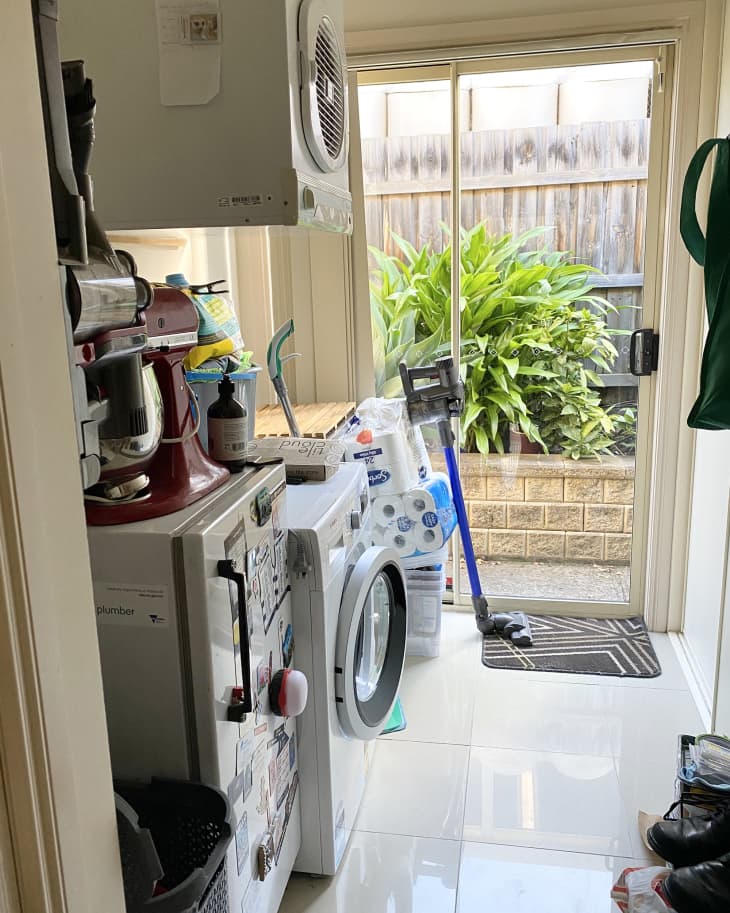 White cluttered laundry room before renovation