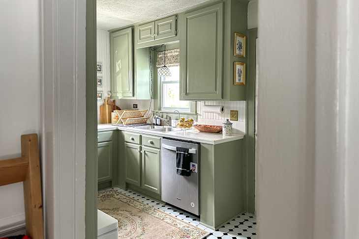 Green painted cabinets in newly painted kitchen.