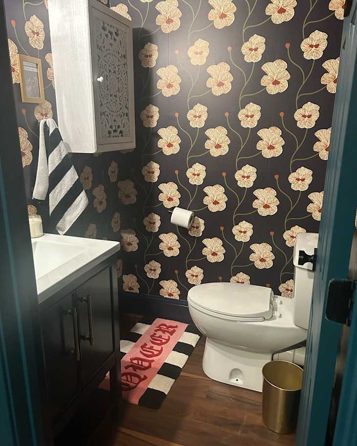 Floral pattern wallpaper  in black bathroom after project