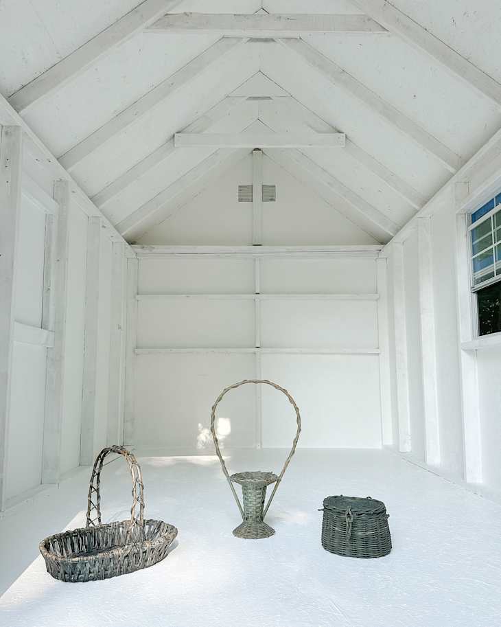 Three woven baskets in a bright, empty room with white walls and a sloped ceiling.
