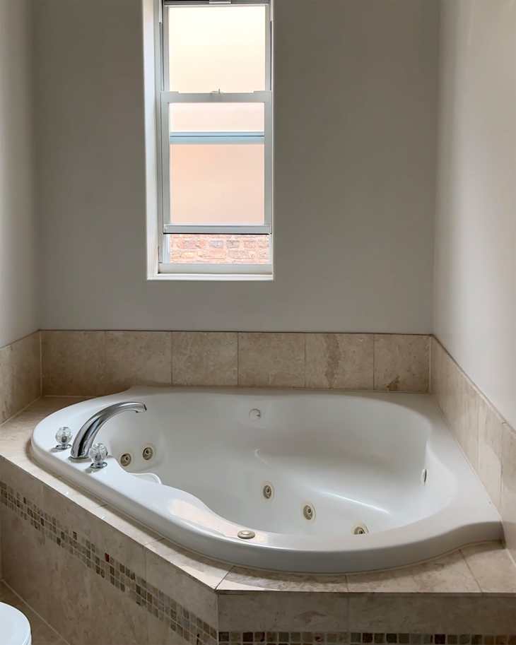 Jet tub in corner of bathroom before renovation.