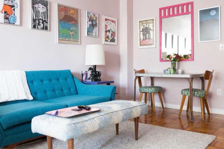 Small living room with teal sofa, coffee table, rug, and pink painted walls