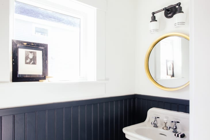 A bathroom with navy blue wainscoting and white upper walls
