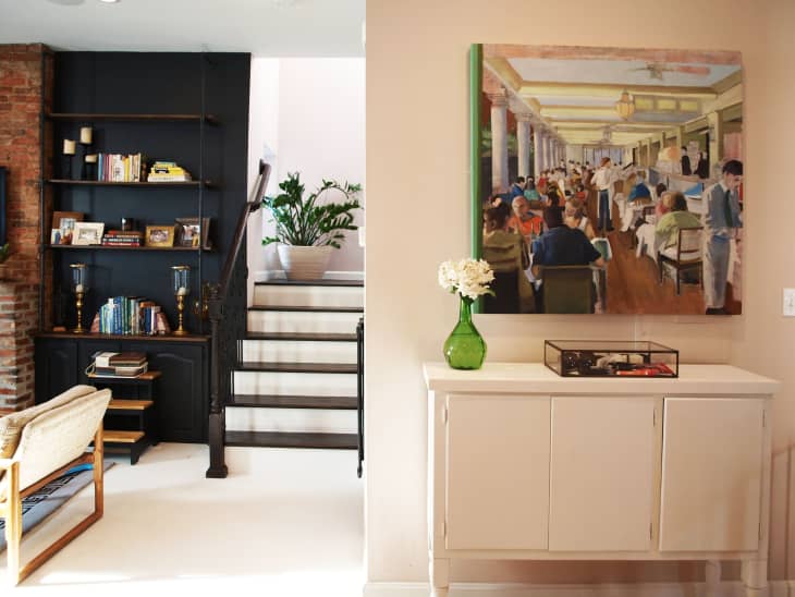 A modern entryway with a large painting above a white cabinet