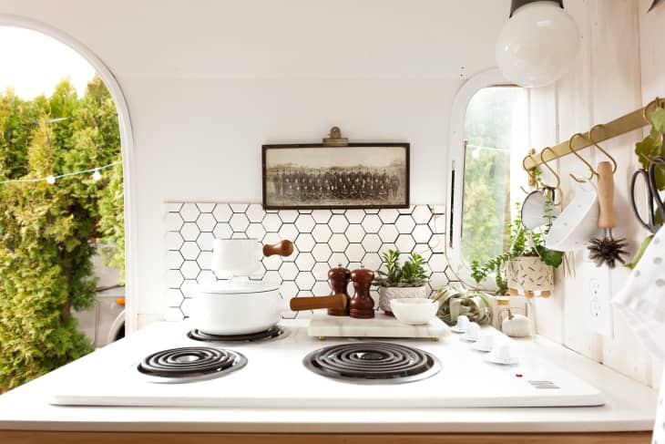 White hexagon tile with black grout behind an electric range