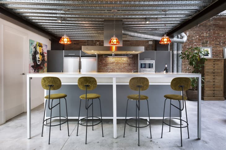 an industrial style kitchen with exposed ceiling and statement lighting