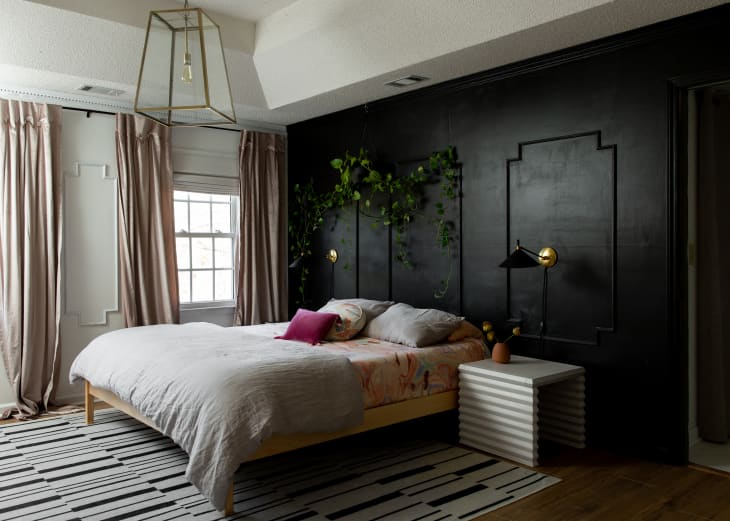 Black walls with decorative wall panels in a bedroom