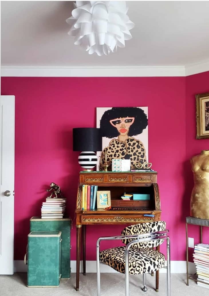 在一个迷人的兼收并蓄的家庭办公室里，热粉色的墙漆
