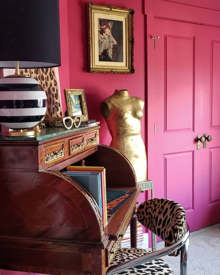 Closeup of antique secretary desk, leopard print desk chair and black and white striped lamp