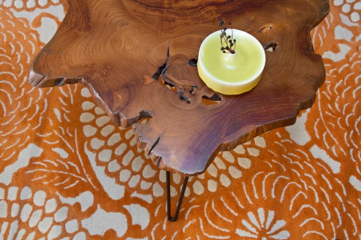 Live edge coffee table with hairpin legs on top of an orange and white rug