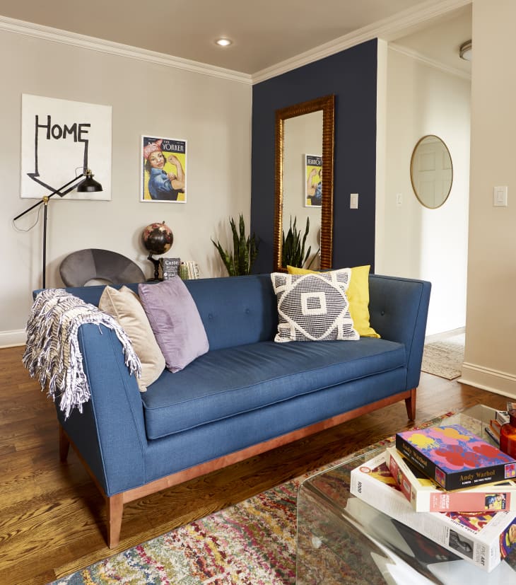Blue sofa with eclectic pillows in a warm industrial modern loft