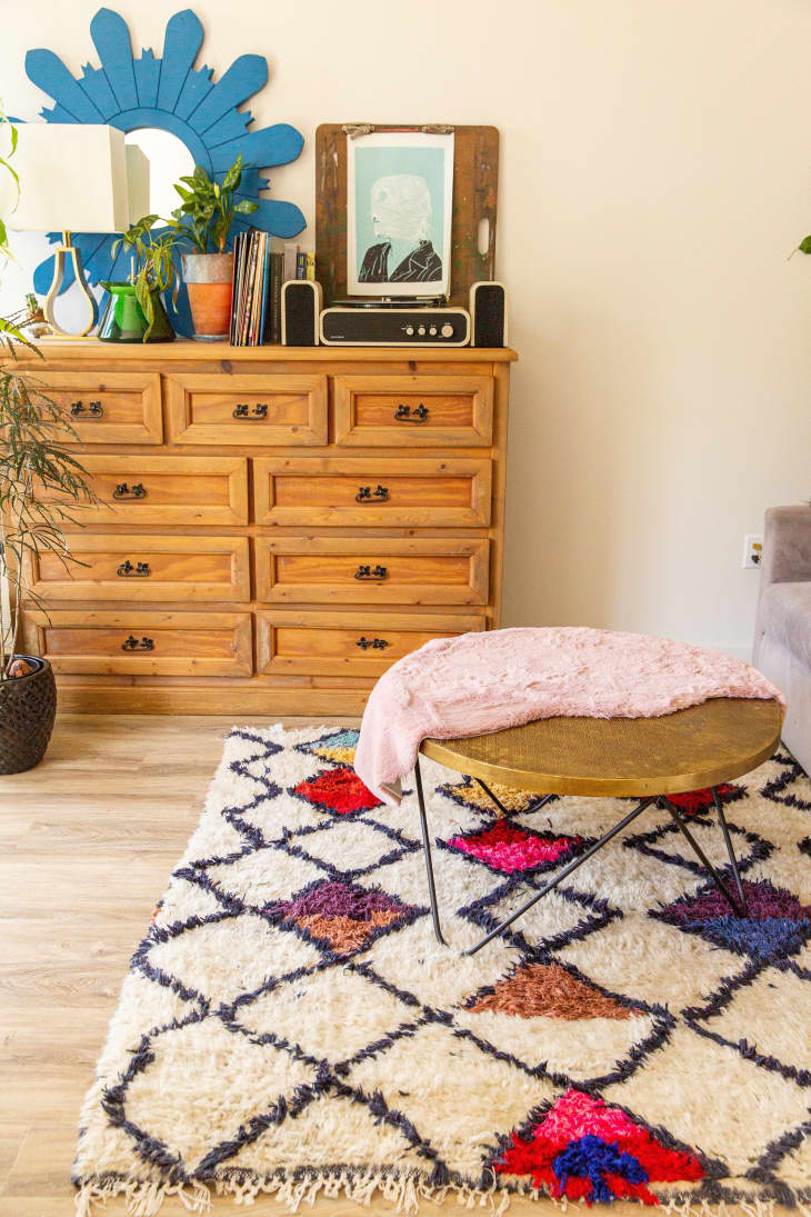 Colorful Moroccan rug next to a heavy vintage wooden dresser