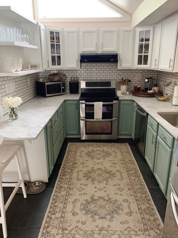 Traditional farmhouse style kitchen with mint green bottom cabinets and white upper cabinets and white subway tile