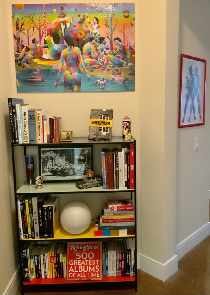 Shelf with colorful toys and accessories and colorful artwork above