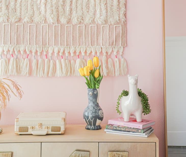 Cream-colored tapestry above accessorized cabinet