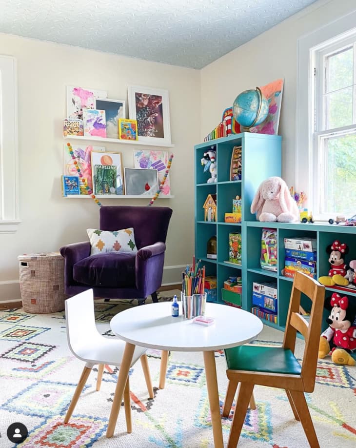 Playroom with blue shelving, purple armchair, and small work table