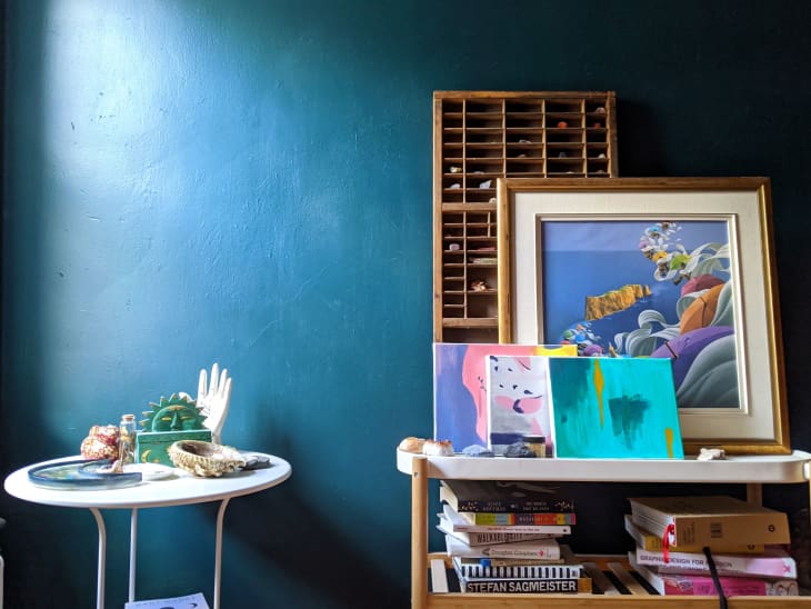 Blue and purple decor on cart and accent table in front of teal wall