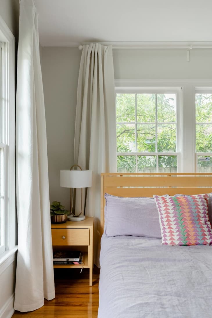 Bedroom with several windows and light blue-gray linens