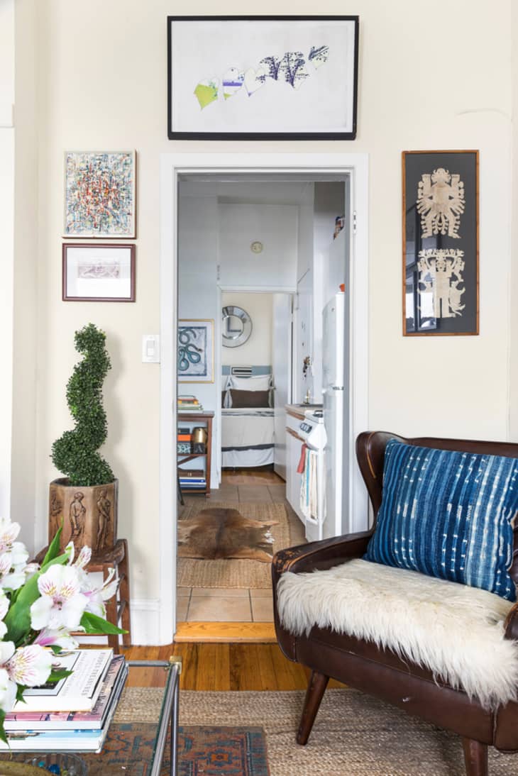 Doorway into kitchen framed by artwork. Leather chair in front of door.