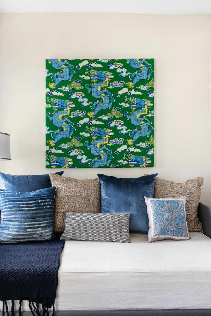 Blue and green dragon artwork above daybed with blue and tan pillows