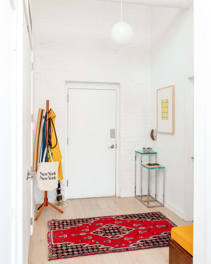 Red oriental rug in white entryway