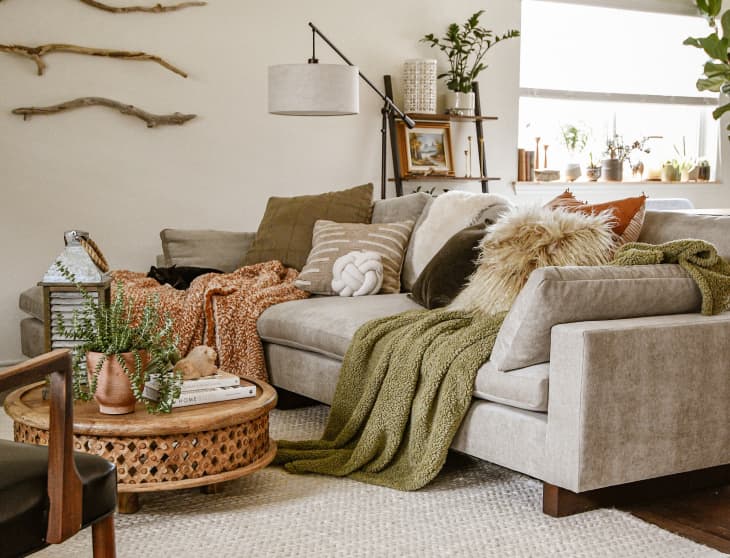 Gray sofa in living room with textured pillows and blankets