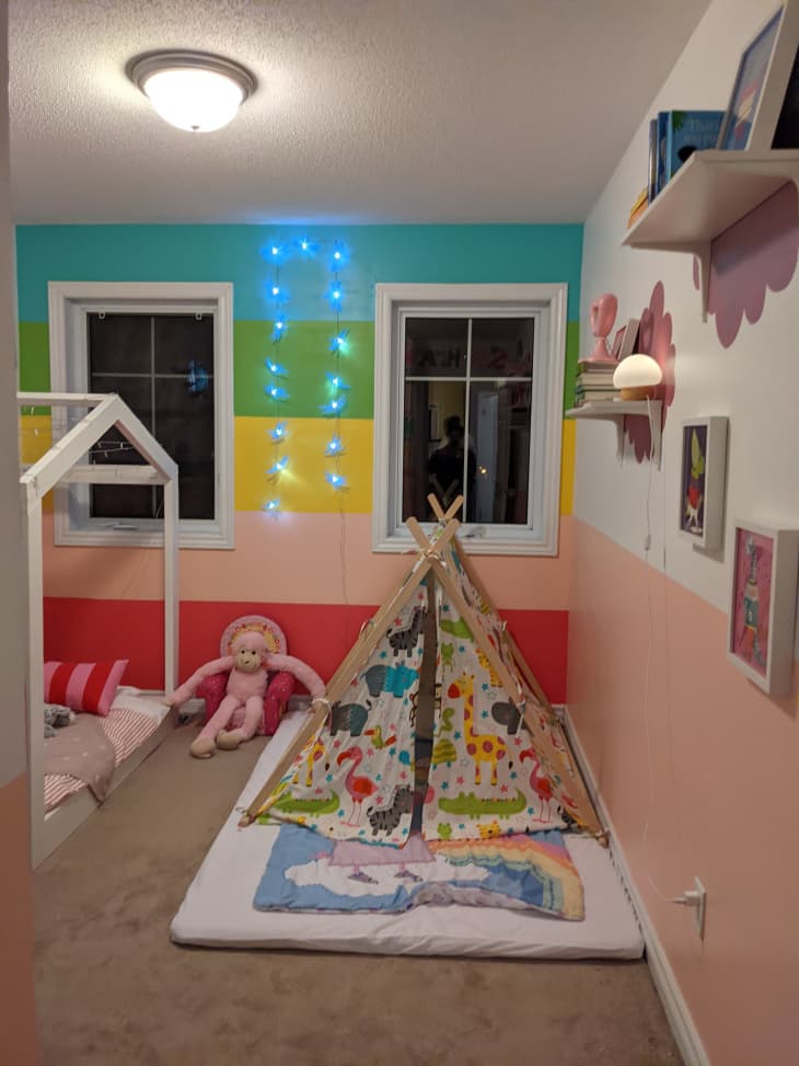 Kid's room with rainbow stripe wall and teepee tent