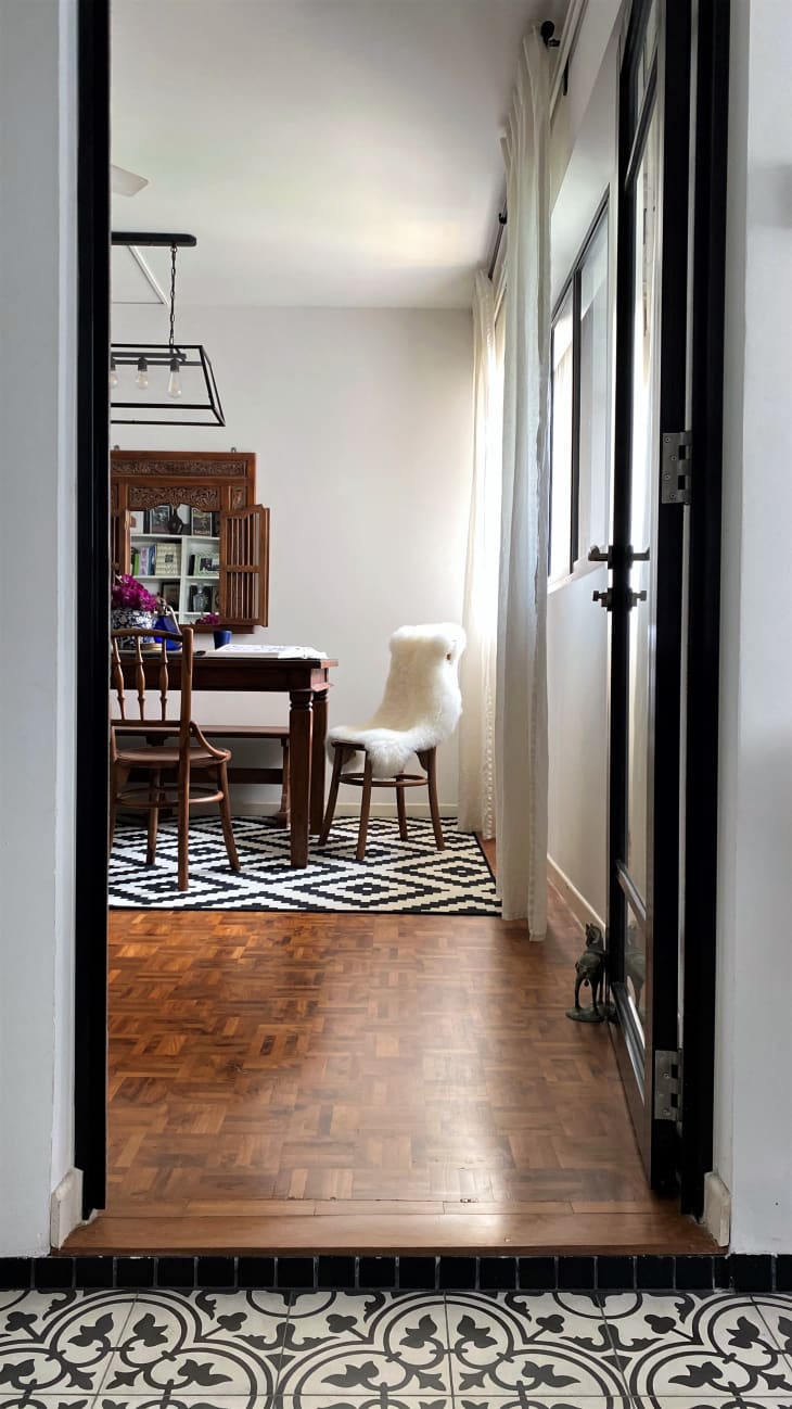 View into dining room with wood flooring and black and white graphic rug