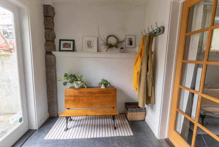 Entryway with bench, hooks, and plants