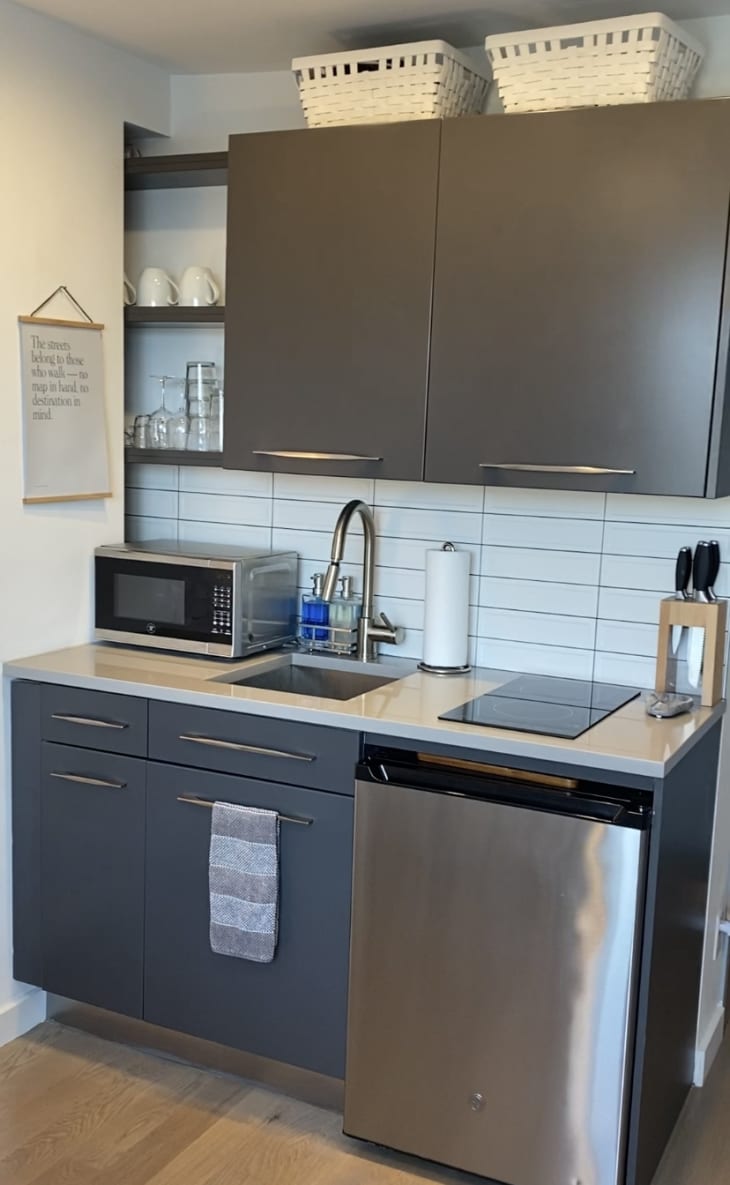 光滑紧凑的厨房，配有微波炉，水槽，洗碗机和灰色橱柜