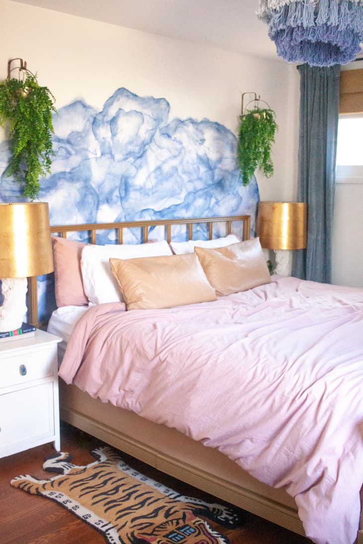 Bedroom with soft pink bedding and blue agate wall art