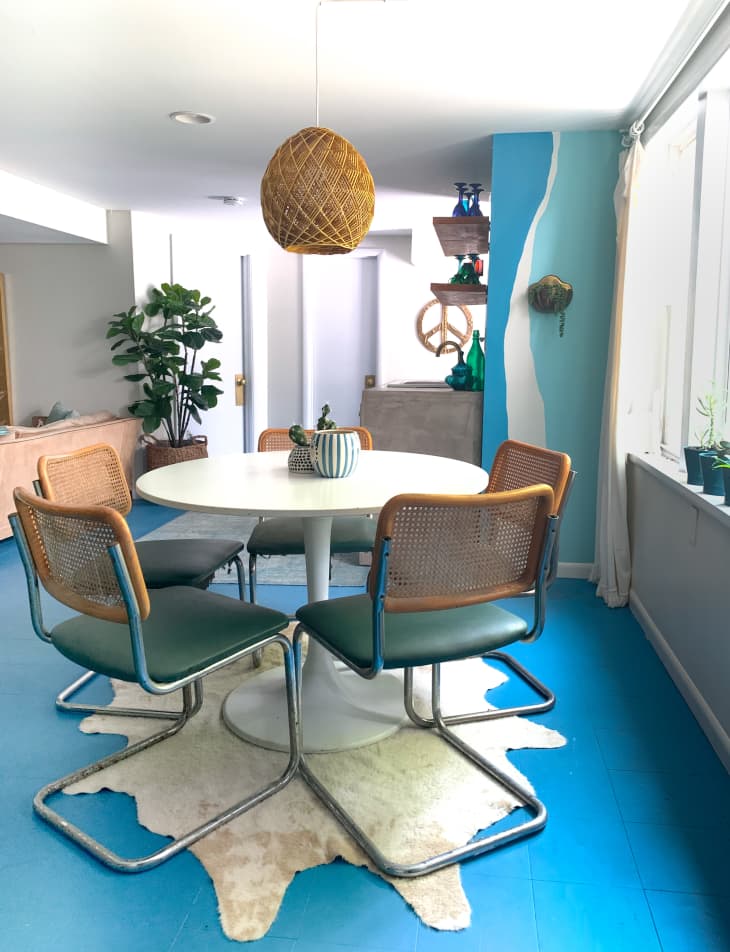 餐厅用蓝色地板,包揽词讼复古的椅子,and wicker pendant light above round table
