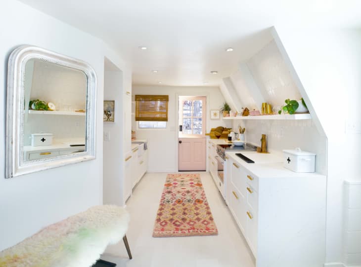 Kitchen with angled walls and pink door to outside