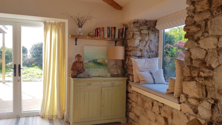 Reading nook and window in the middle of a stone wall
