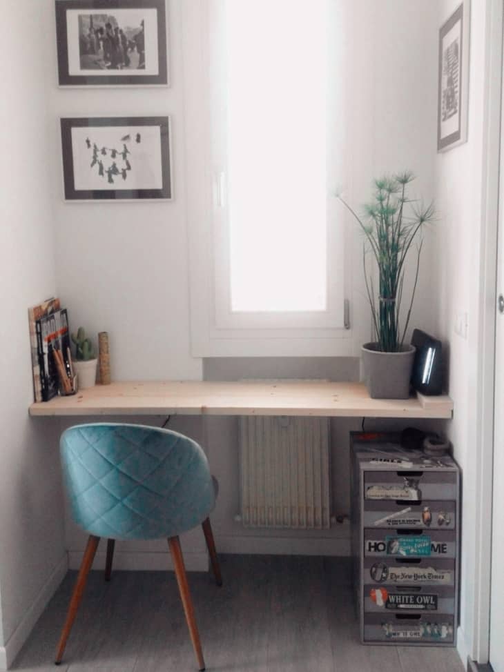 Floating desk with blue chair beneath window