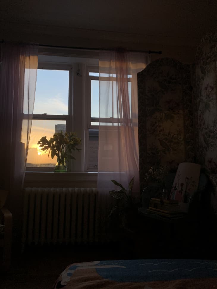 Window with sheer curtains glowing in sunset