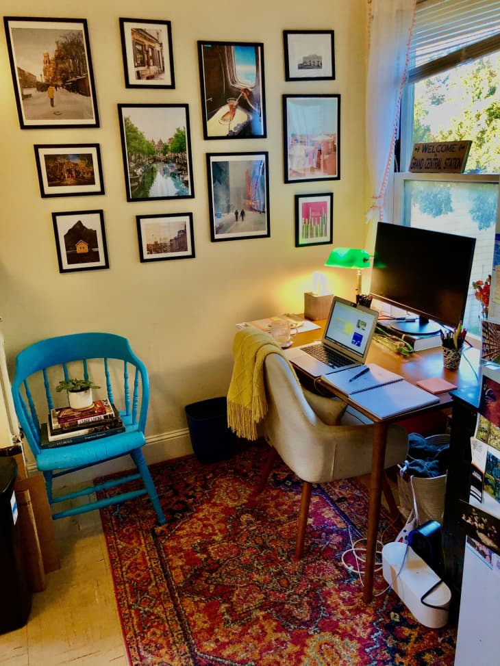 WFH area with vintage red rug and photos in frames hanging on the wall